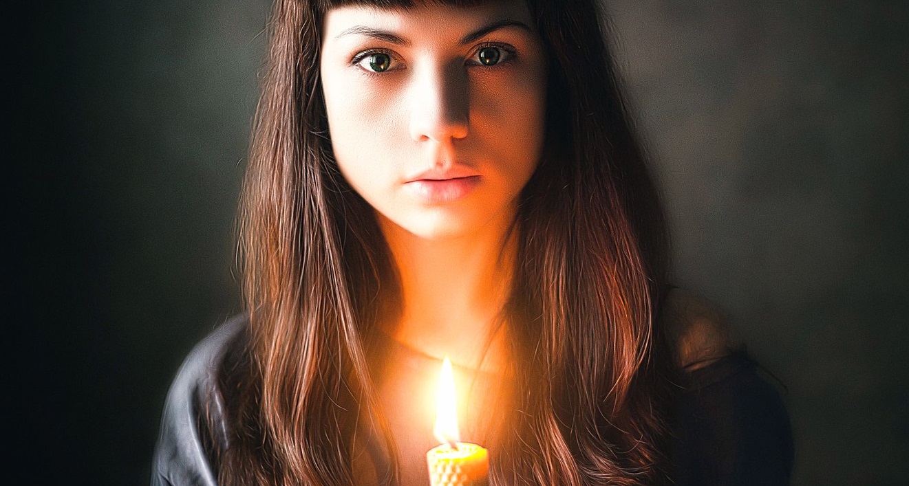 Женщина молится при свечах. Девушка смотрит на свечу. Как снять красивый портрет со свечой. Фото при свечах девушка.
